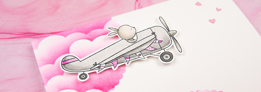 Close up of stamped bunny in an airplane with a string of flags hanging off it.