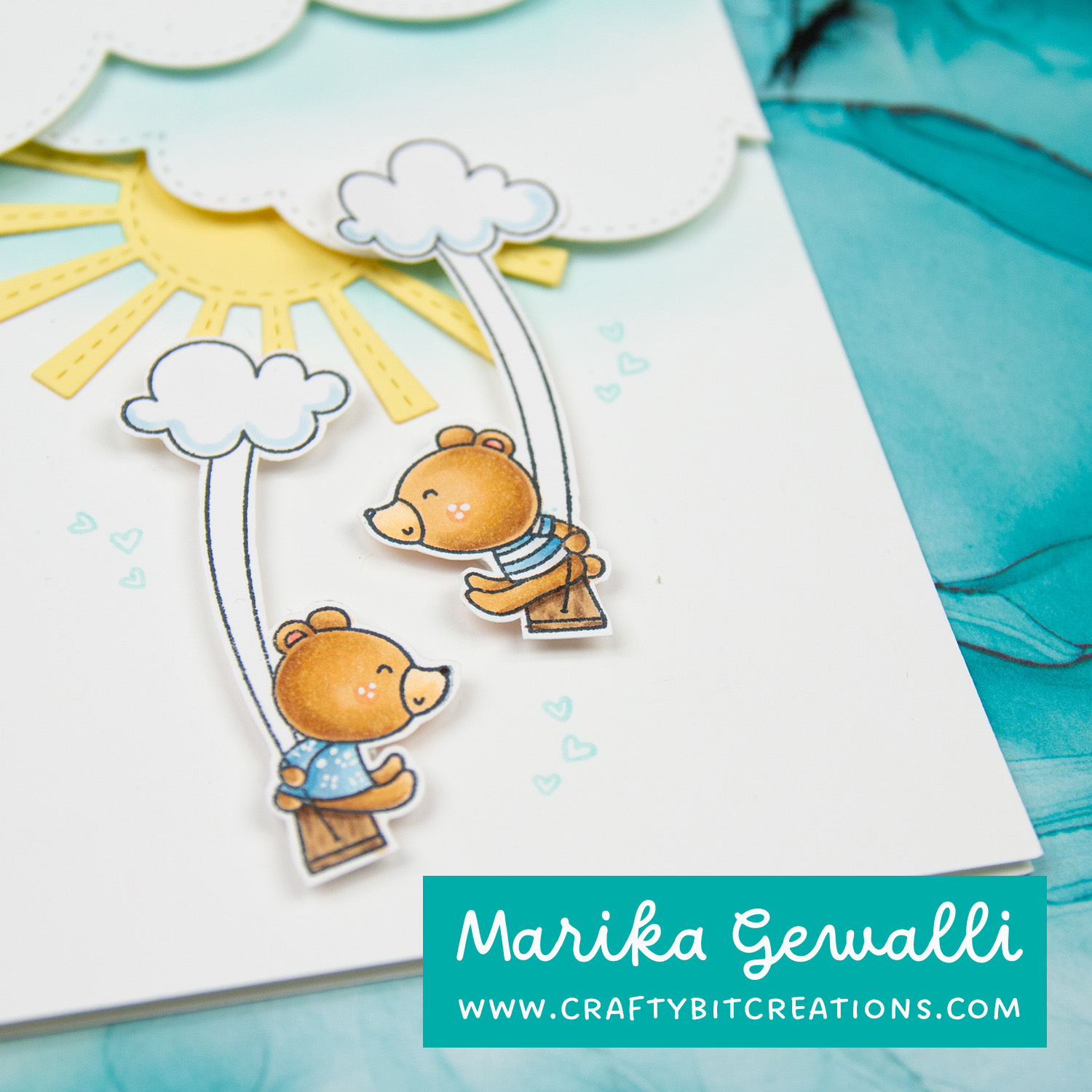 Close up of two stamped and colored bears swinging on swings hanging from clouds.