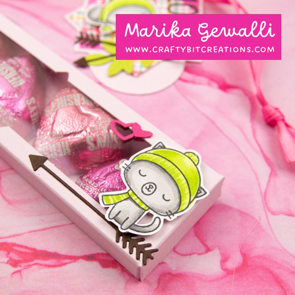 closeup of light pink decorated box with 4 hershey's hearts inside and a coordinating tag