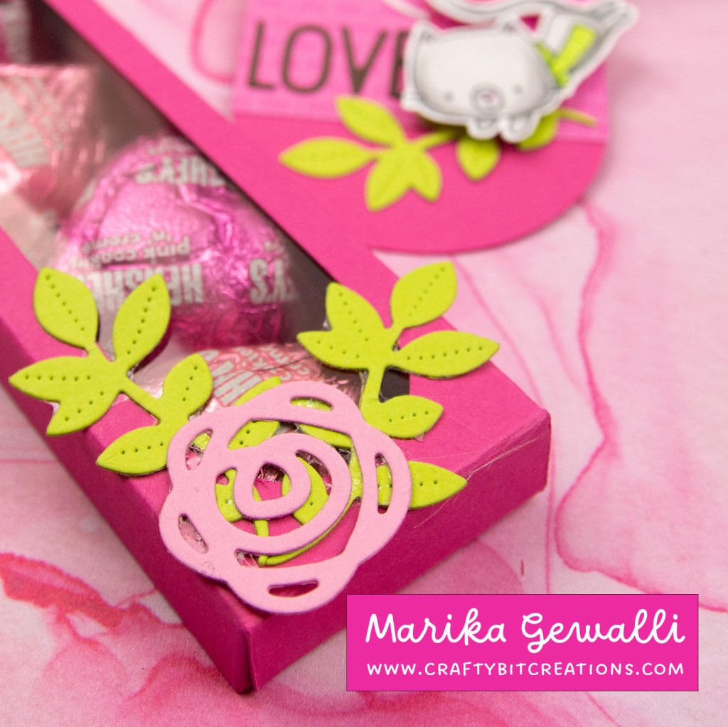 close up dark pink decorated box with 4 hershey's hearts inside and a coordinating tag