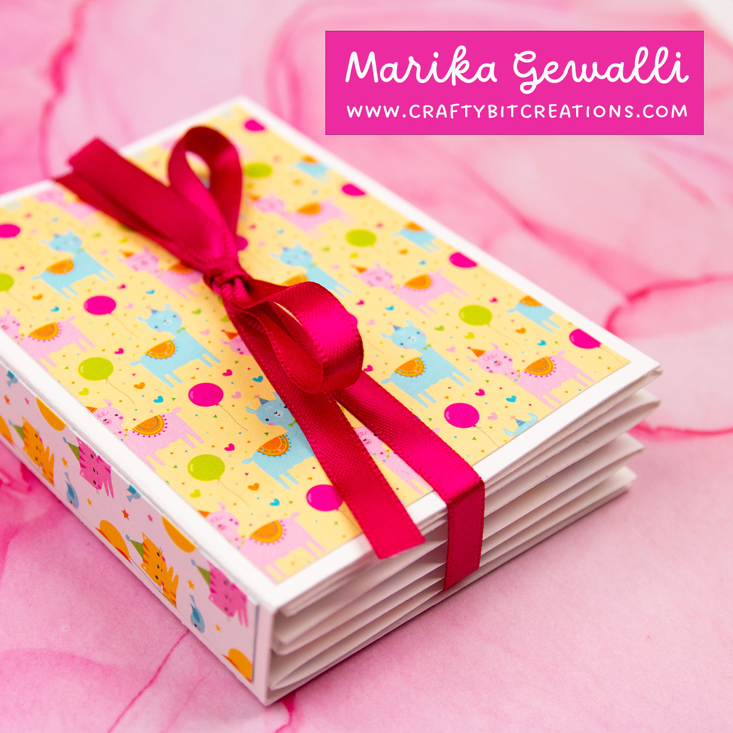 Close up of accordion album tied together with hot pink ribbon