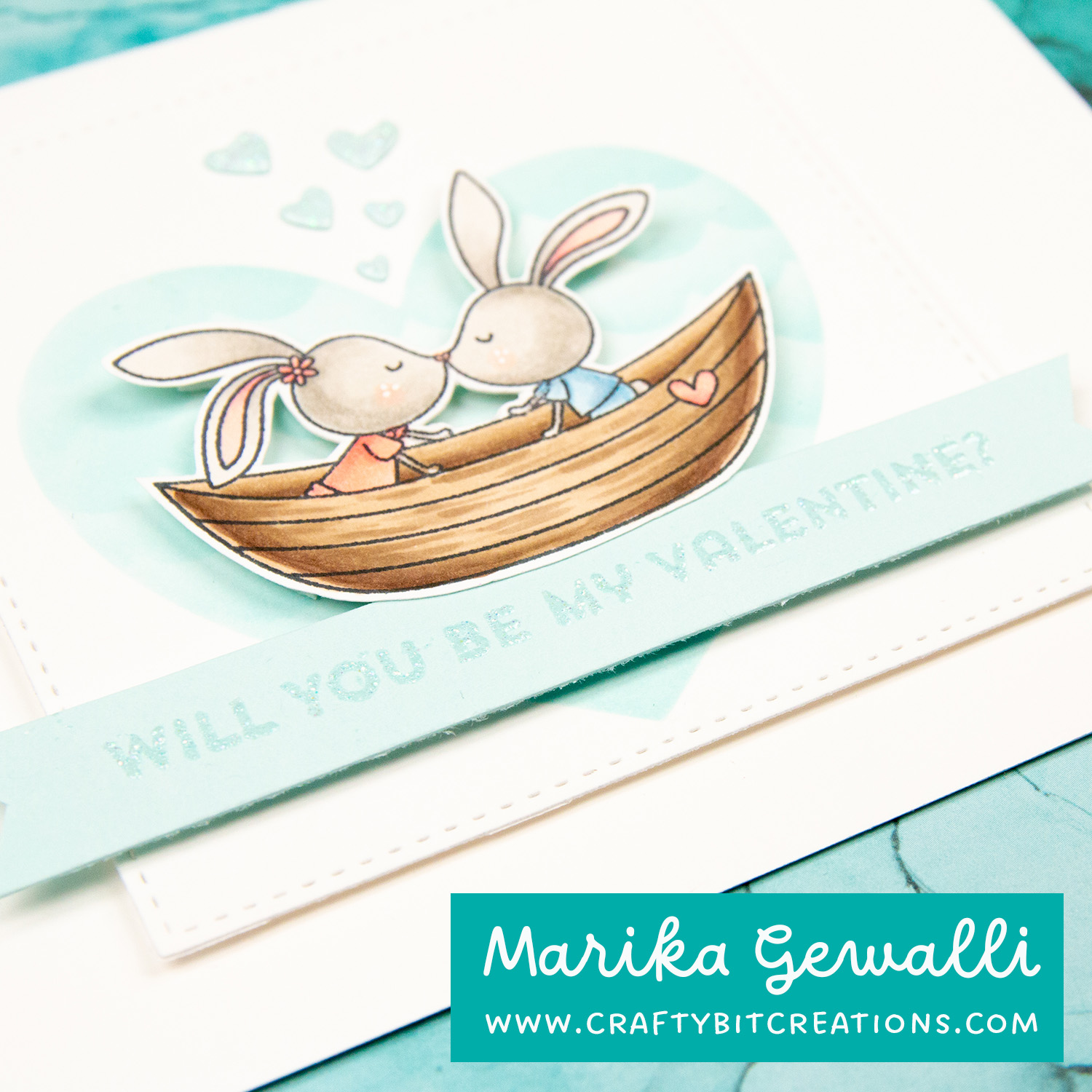 closeup blue valentines card, two bunnies in a boat with a heart as backdrop