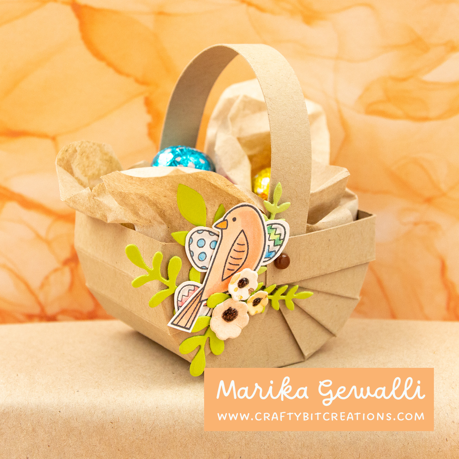side view of kraft easter basket decorated with branches, some copic colored stamped eggs, a stamped and copic colored bird and some diecut flowers. Filled with Lindt chocolate eggs