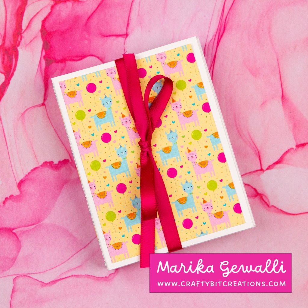 Accordion album tied together with a hot pink ribbon