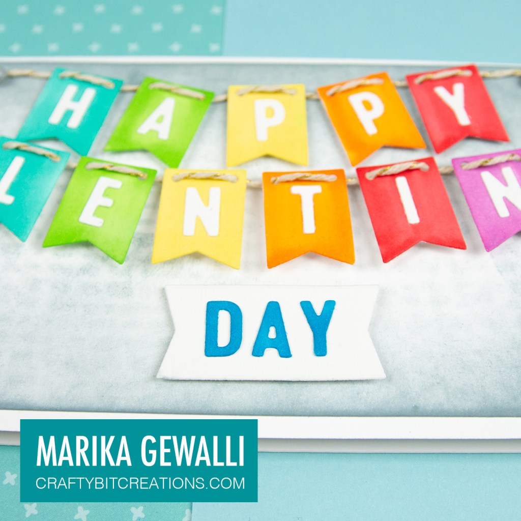 Close up of middle of Slimeline card showing a colored cartoon cat and the letters HAPPYLENTI on rainbow banner flags