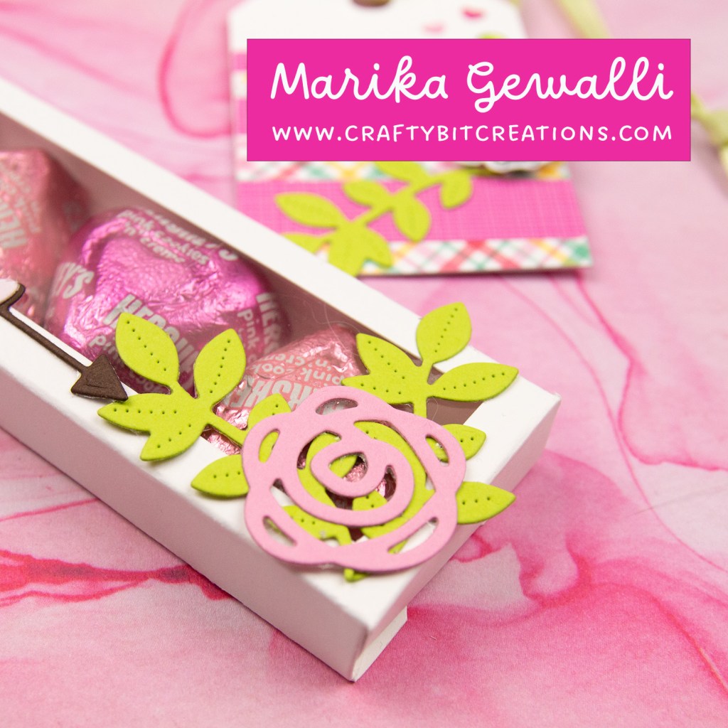 close up of white decorated box with 4 hershey's hearts inside and a coordinating tag