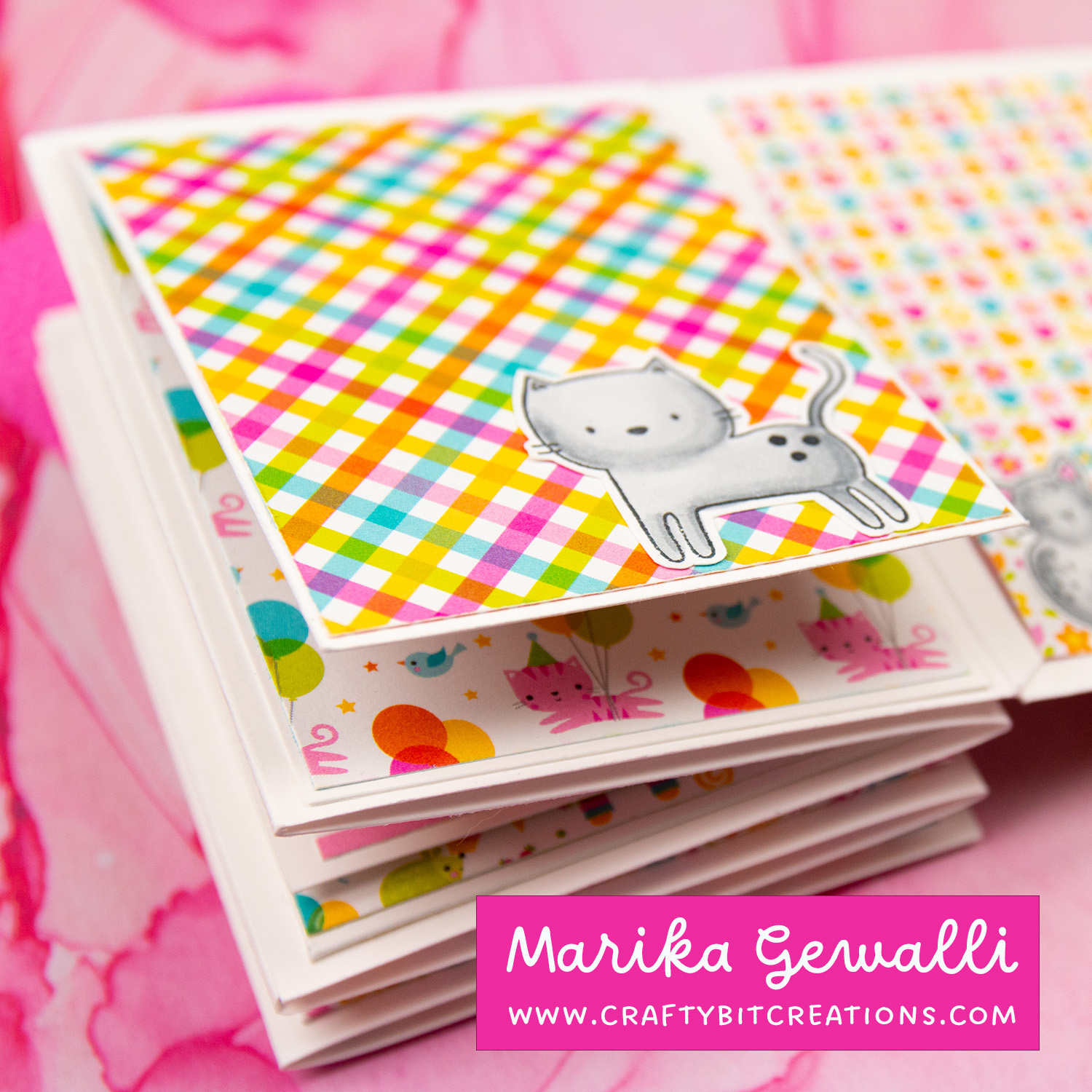 Close up of fifth spread of accordion album decorated with colorful pattern paper and a stamped cat