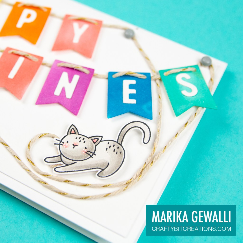 Close up of right side of Slimeline card showing a colored cartoon cat and the letters on rainbow banner flags