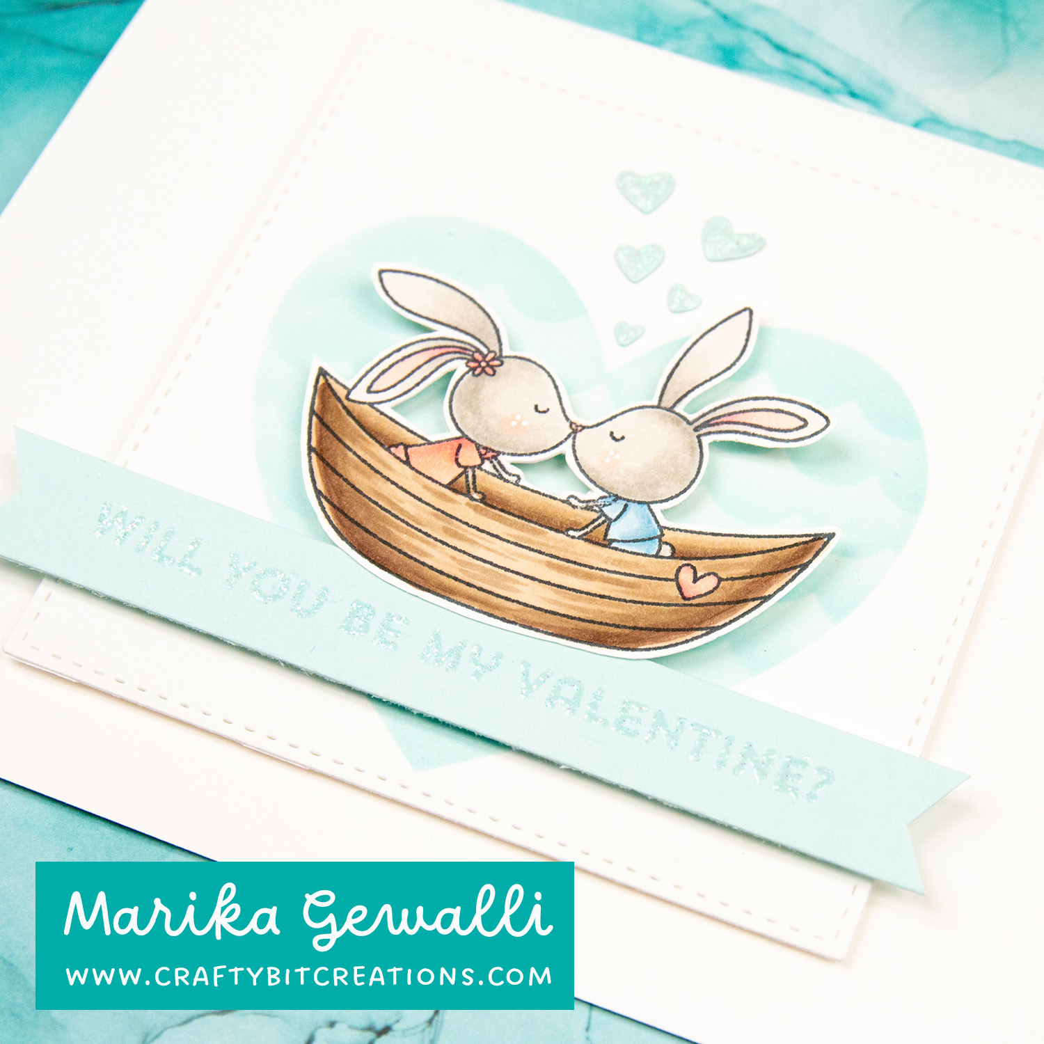 closeup blue valentines card, two bunnies in a boat with a heart as backdrop